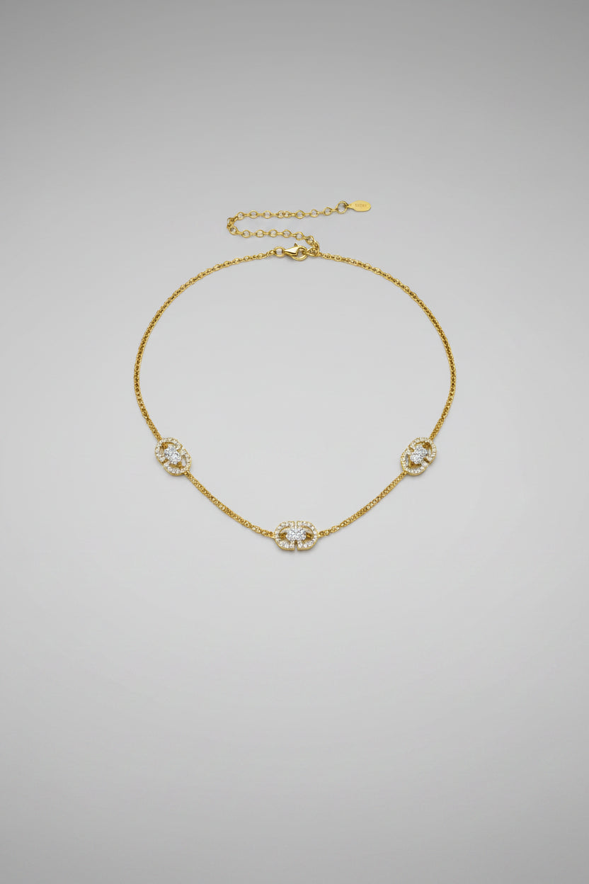 A gold chain necklace featuring three interlocking double-G logo charms.