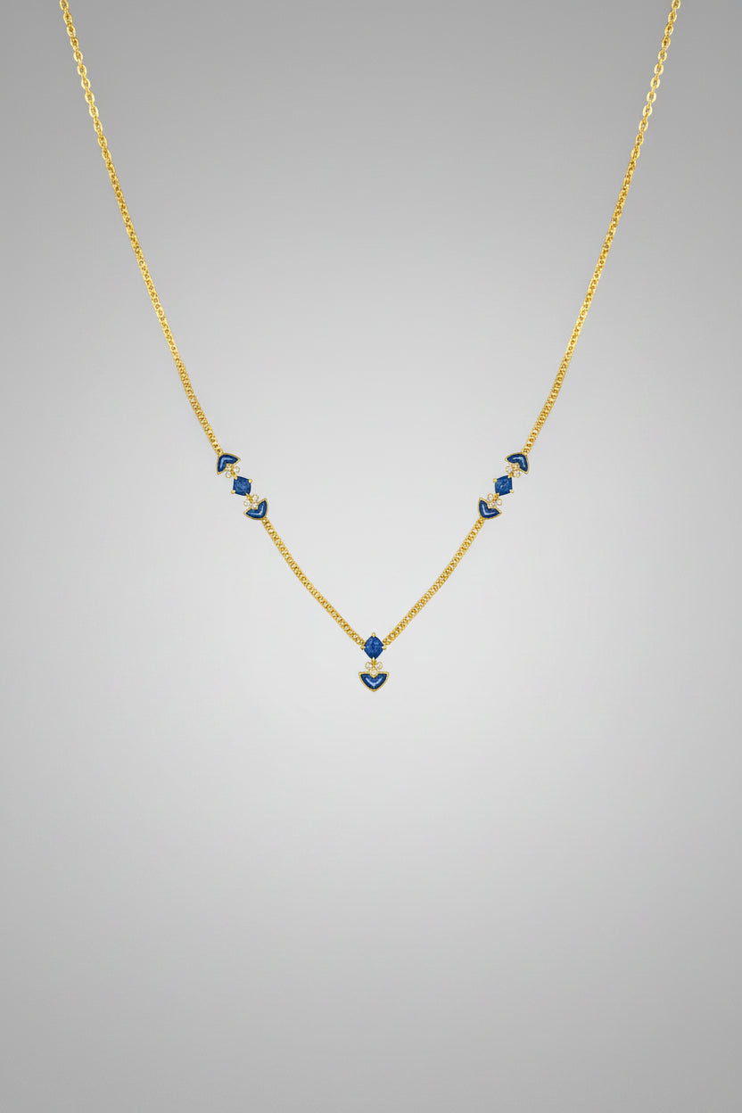 A delicate gold chain necklace featuring small blue and white floral bead accents on each side and a matching blue floral pendant at the center.