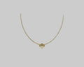 A delicate gold chain necklace with a small geometric pendant featuring a stylized 'V' design.
