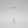 A delicate gold necklace with a central pendant featuring a light blue rectangular stone, a small gold accent, and a dangling blue teardrop gemstone.