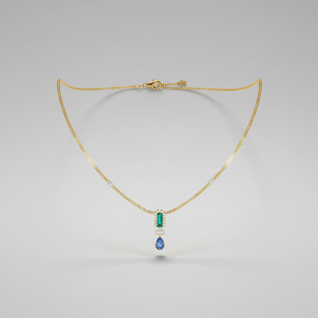 A delicate gold necklace with a central pendant featuring a light blue rectangular stone, a small gold accent, and a dangling blue teardrop gemstone.