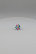 A small multicolored circular accessory or charm centered on a solid black background.