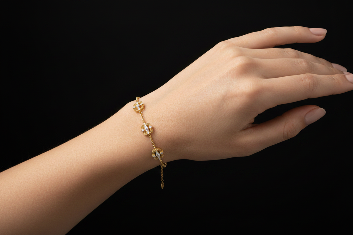Gold chain bracelet with three diamond filigree stations worn on a woman's wrist